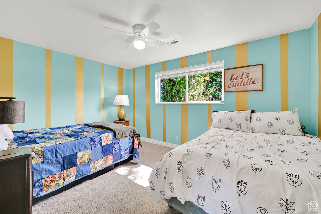 Bedroom with visible vents, baseboards, wallpapered walls, a ceiling fan, and carpet