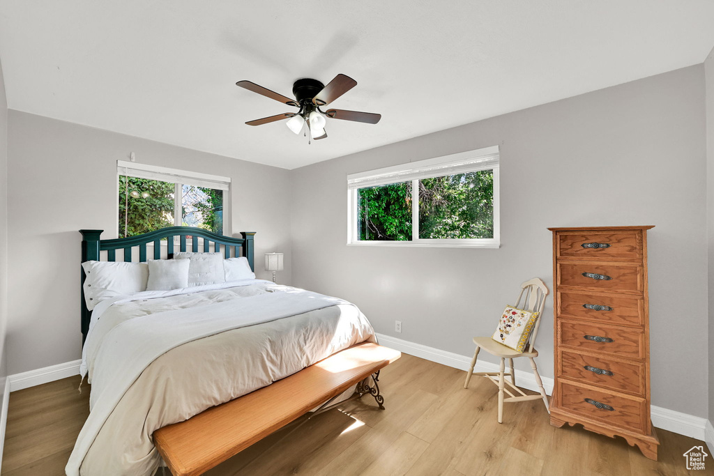 Bedroom with baseboards, light wood-style flooring, and ceiling fan