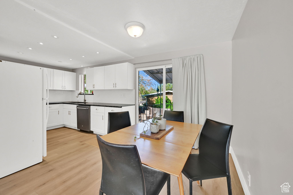Dining room with light wood-type flooring and recessed lighting