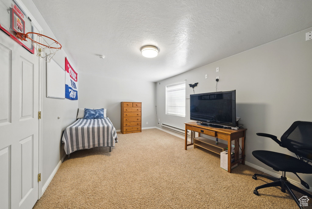 Carpeted bedroom featuring baseboards, a textured ceiling, and baseboard heating