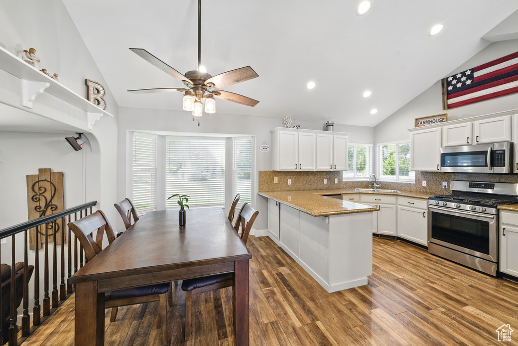 Kitchen featuring a sink, decorative backsplash, a peninsula, and stainless steel appliances