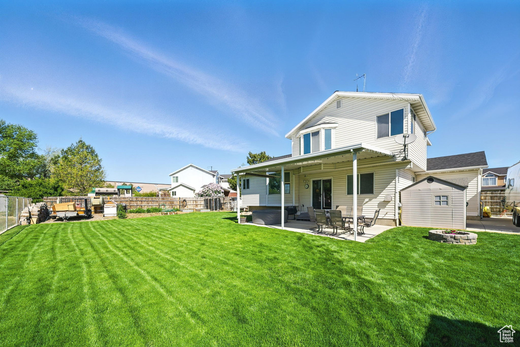 Rear view of house with fence, a patio, and a yard