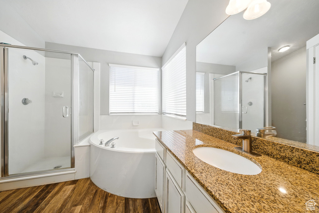 Full bathroom featuring a shower stall, wood finished floors, a garden tub, and vanity