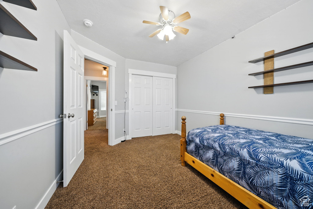 Carpeted bedroom with baseboards, a ceiling fan, and a closet