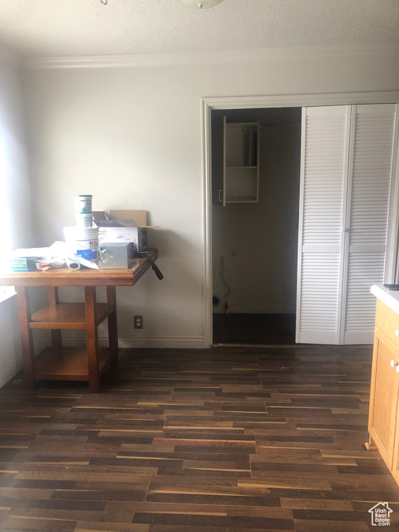 Dining area featuring crown molding, baseboards, and dark wood finished floors