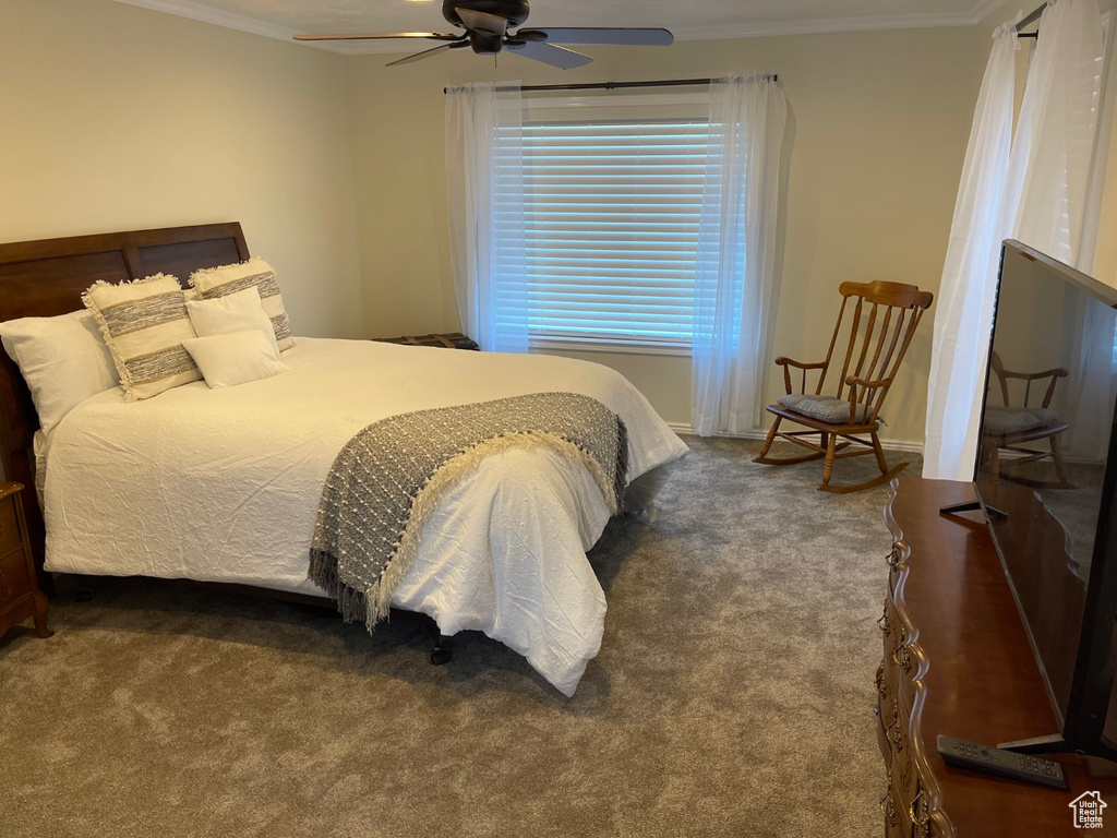 Bedroom with crown molding, ceiling fan, and carpet floors