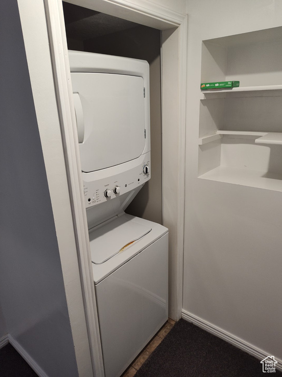 Laundry area featuring stacked washer / drying machine and laundry area