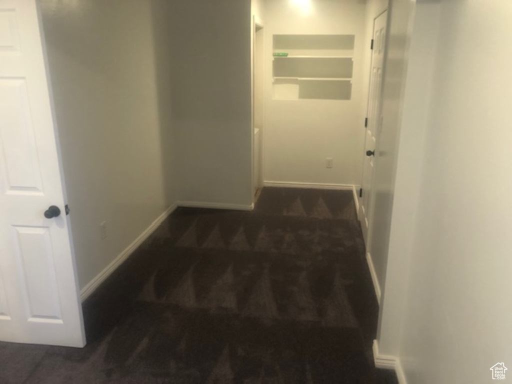 Hallway featuring baseboards and carpet
