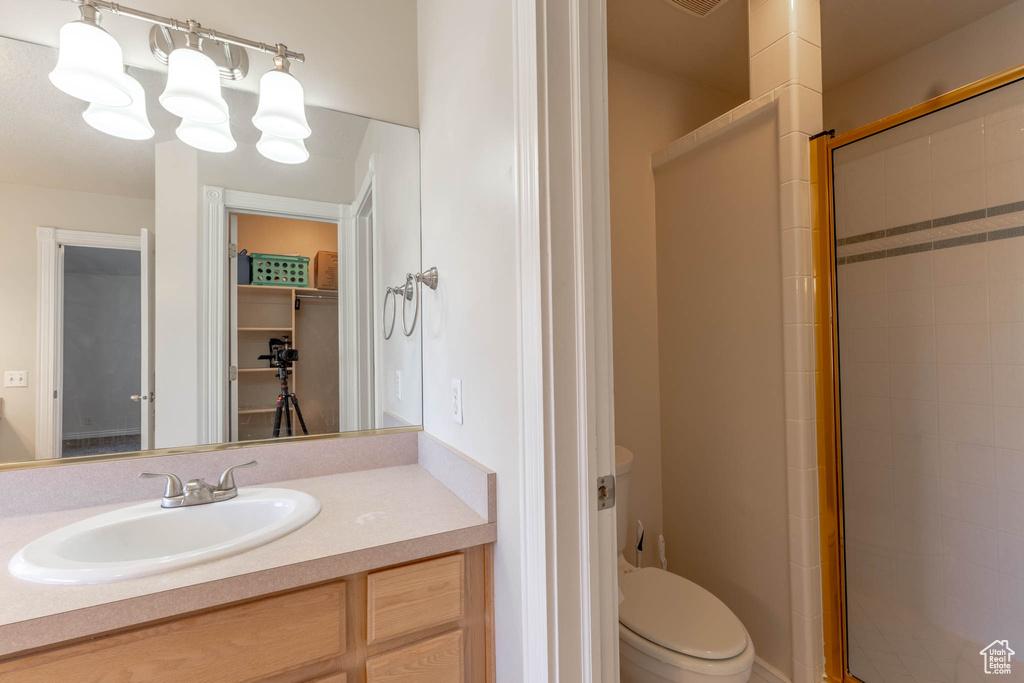Full bath featuring vanity, a stall shower, and toilet