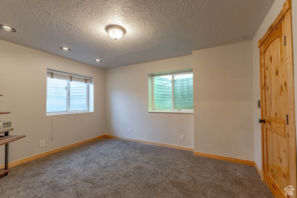 Carpeted spare room with baseboards and a textured ceiling