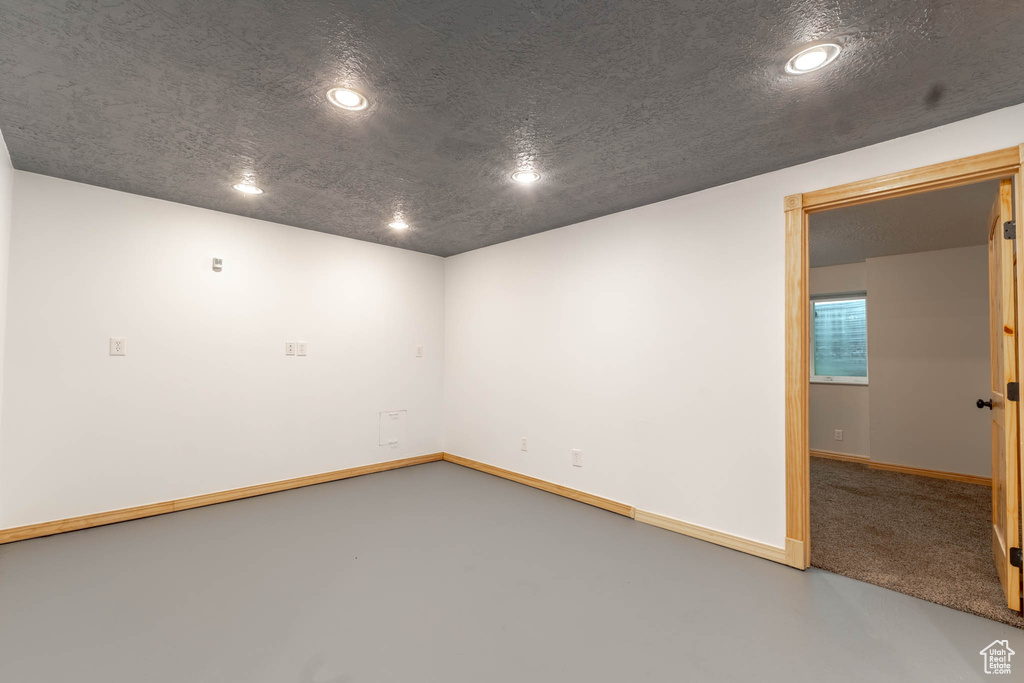 Empty room featuring concrete flooring, baseboards, and recessed lighting