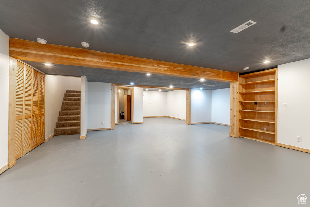 Finished basement featuring stairway, baseboards, recessed lighting, and visible vents