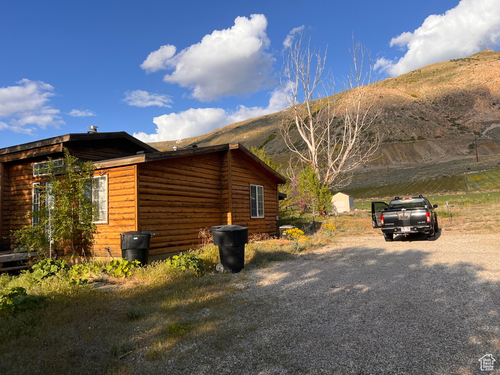 View of property exterior featuring a mountain view and driveway