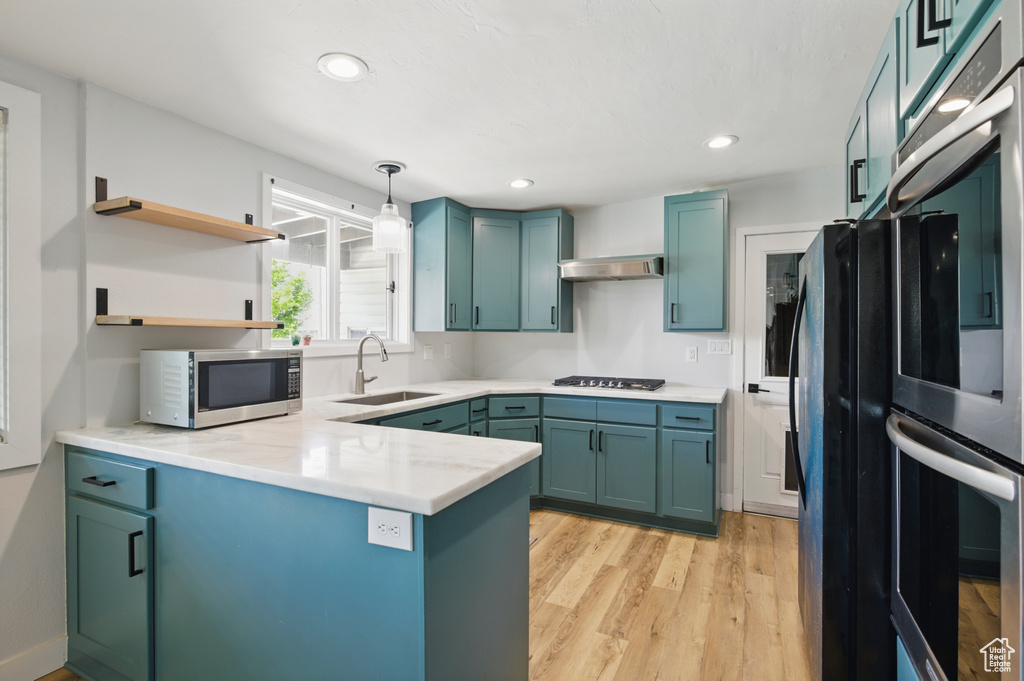 Kitchen featuring a peninsula, recessed lighting, a sink, light wood-style flooring, and stainless steel appliances