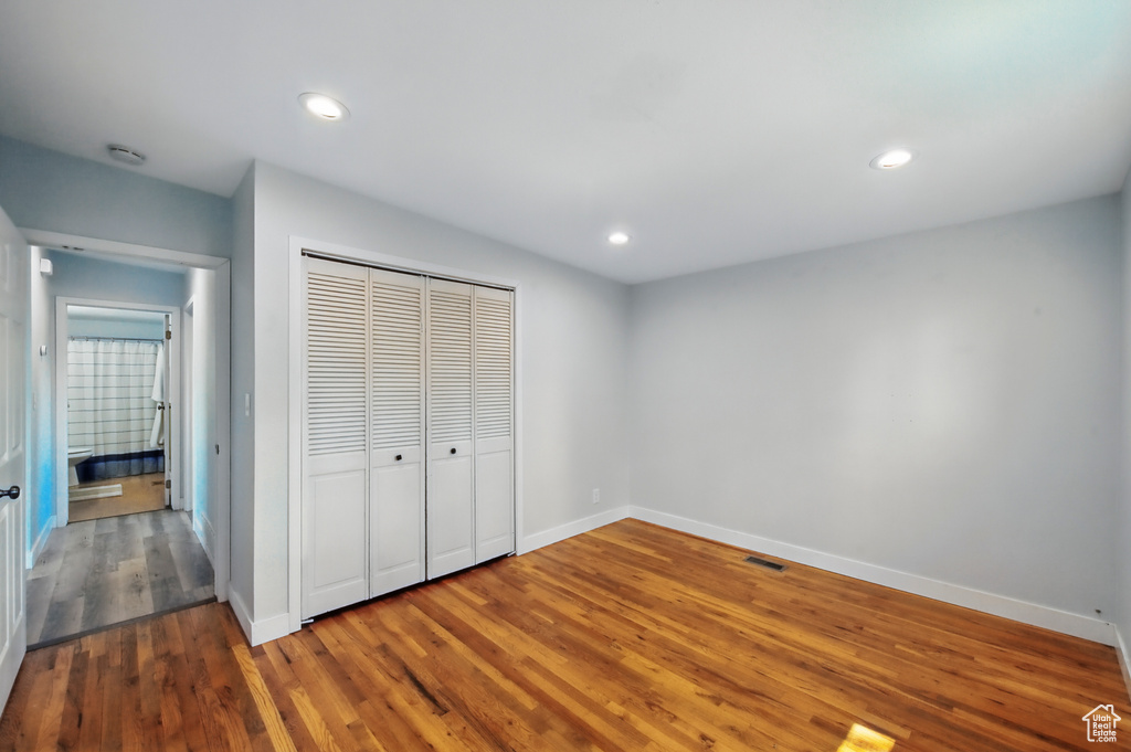 Unfurnished bedroom featuring visible vents, wood finished floors, baseboards, a closet, and recessed lighting