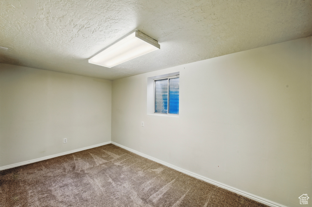 Carpeted spare room with baseboards and a textured ceiling