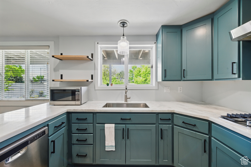 Kitchen featuring a sink, appliances with stainless steel finishes, green cabinetry, and a healthy amount of sunlight