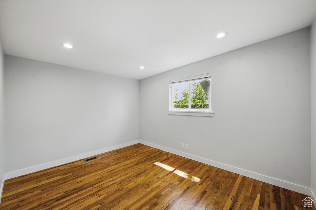 Unfurnished room with baseboards, recessed lighting, wood finished floors, and visible vents