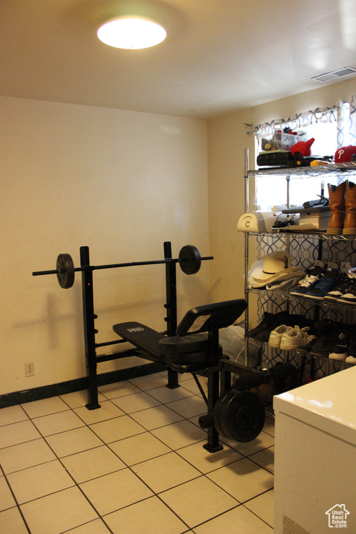 Workout area featuring baseboards, visible vents, and light tile patterned floors