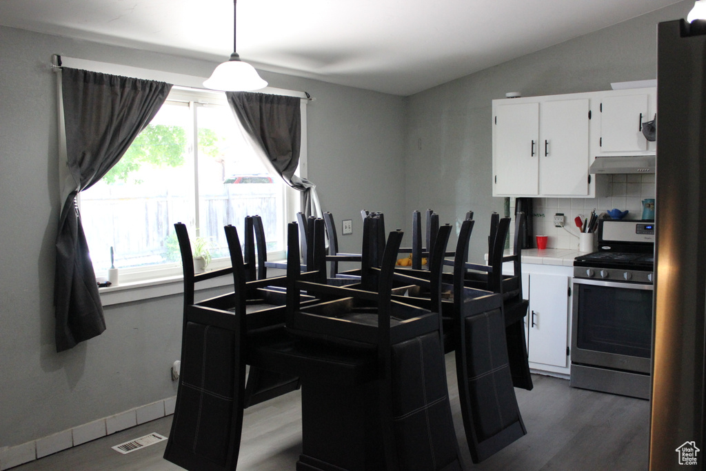Dining room with baseboards, visible vents, dark wood finished floors, and lofted ceiling