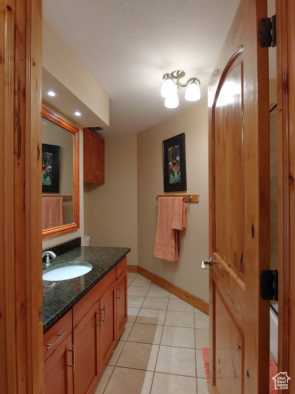 Bathroom featuring baseboards, tile patterned flooring, vanity, and recessed lighting