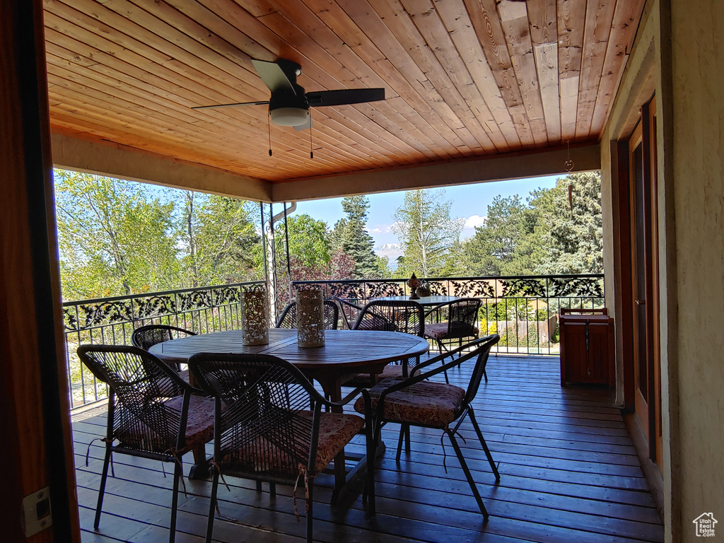 Wooden deck featuring a ceiling fan and outdoor dining space
