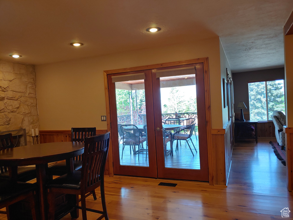 Dining room with french doors, wainscoting, and wood finished floors