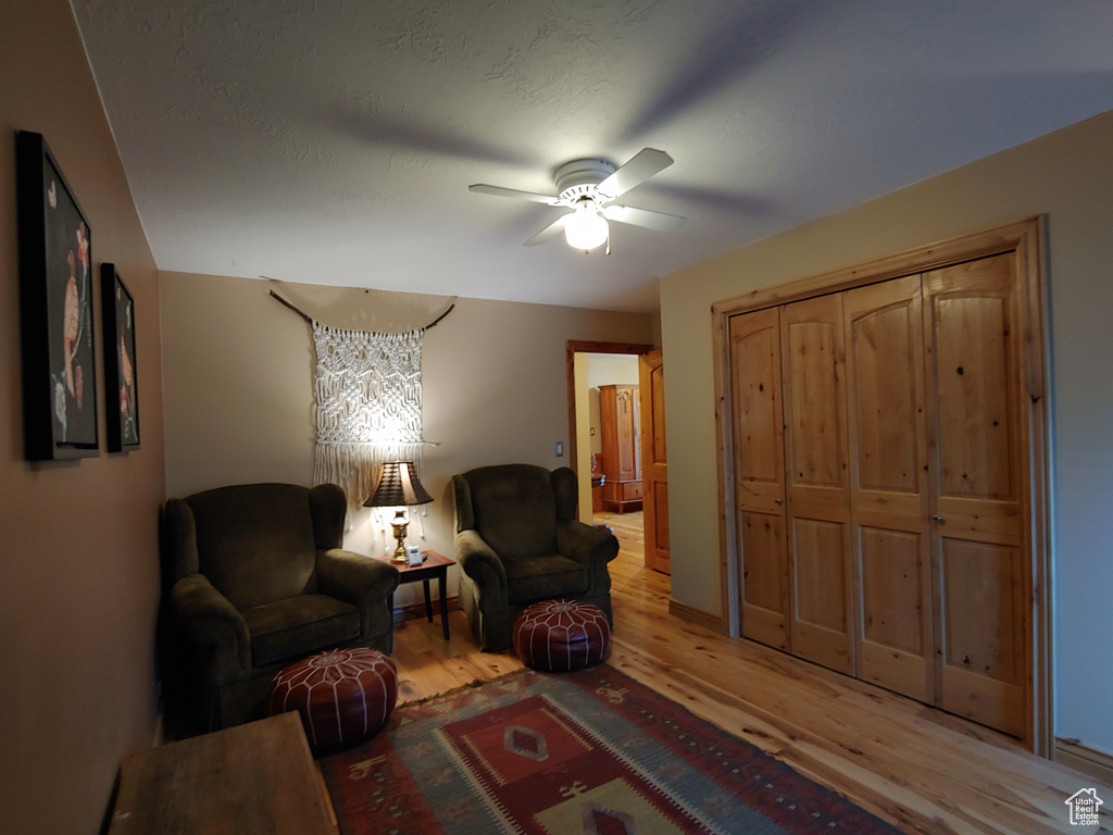 Living area with light wood-type flooring and ceiling fan