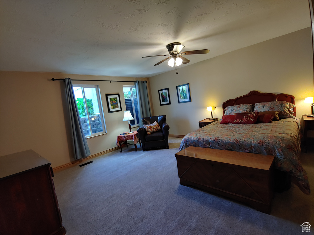 Carpeted bedroom with a ceiling fan, baseboards, and visible vents