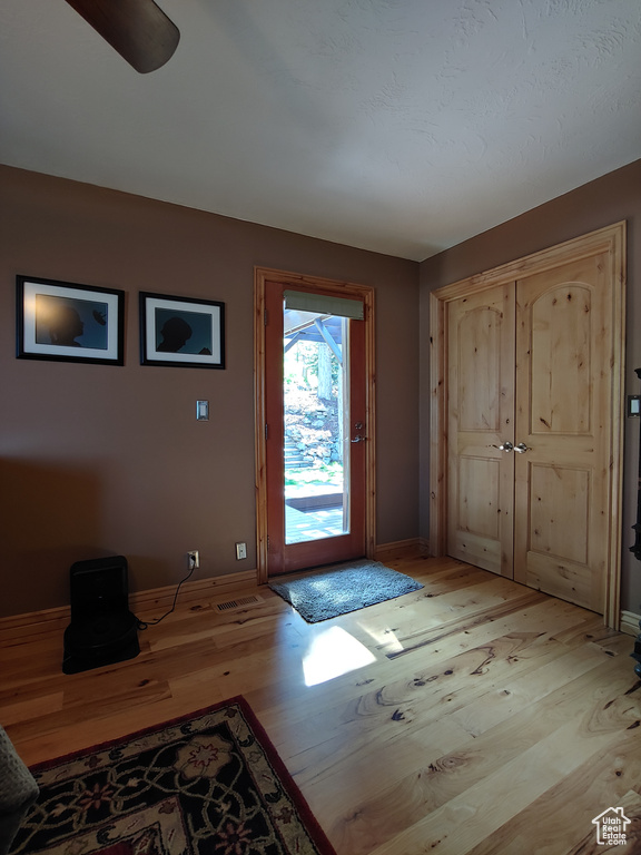Doorway with baseboards and light wood-style floors