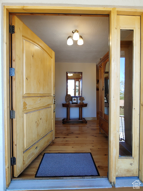 Doorway featuring baseboards and light wood-type flooring