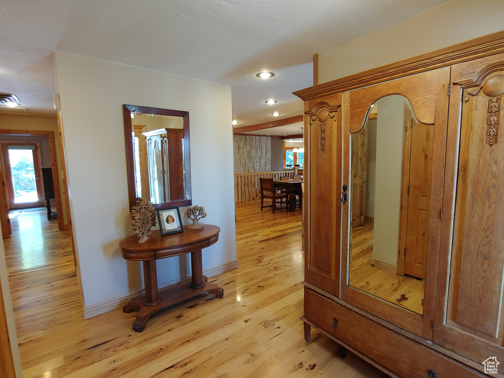 Hall featuring recessed lighting, baseboards, a wealth of natural light, and light wood-style flooring