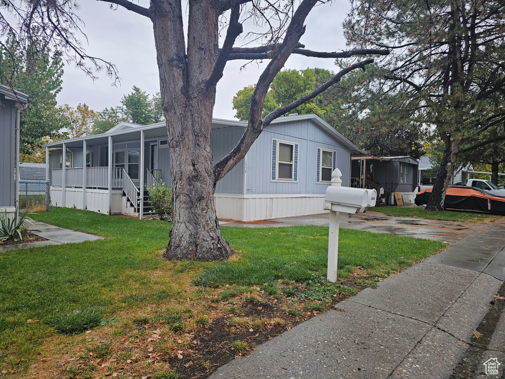 View of front of property with a sunroom and a front lawn