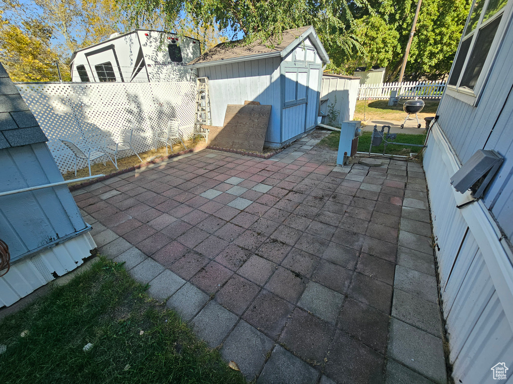 View of patio / terrace featuring a storage shed, an outbuilding, and a fenced backyard