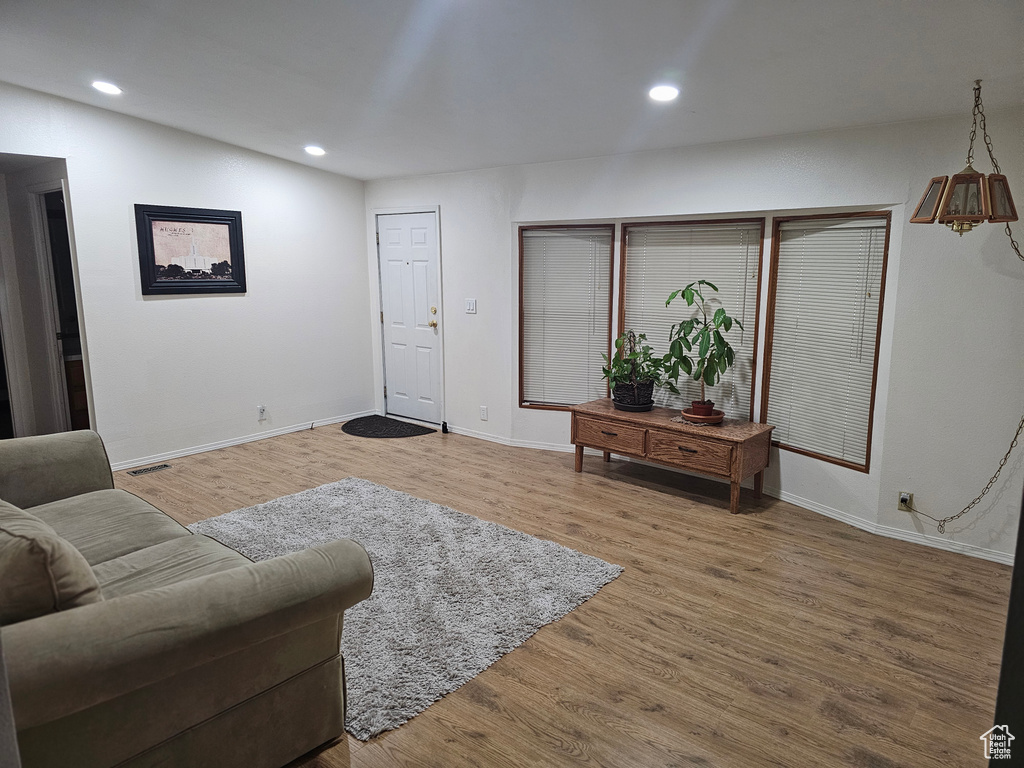 Living room with recessed lighting, baseboards, wood finished floors, and visible vents