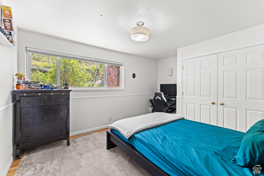 Bedroom featuring baseboards, multiple windows, a closet, and wood finished floors