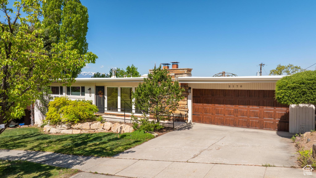 Ranch-style home featuring an attached garage and concrete driveway