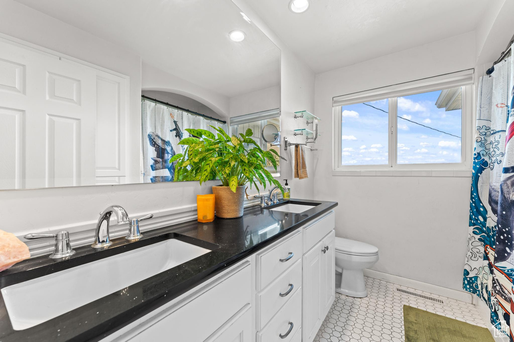 Bathroom featuring a sink, recessed lighting, toilet, and double vanity