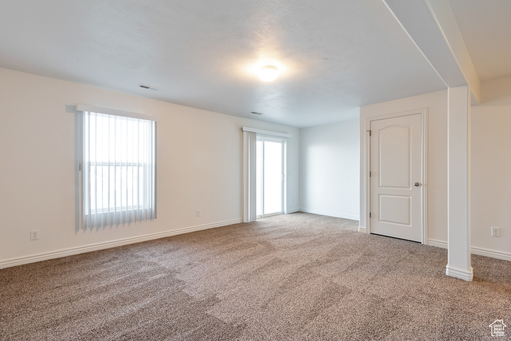 Carpeted spare room with baseboards and visible vents