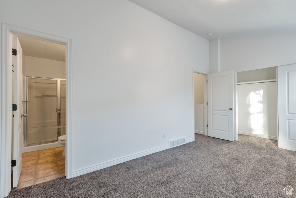 Unfurnished bedroom featuring visible vents, connected bathroom, carpet, and baseboards