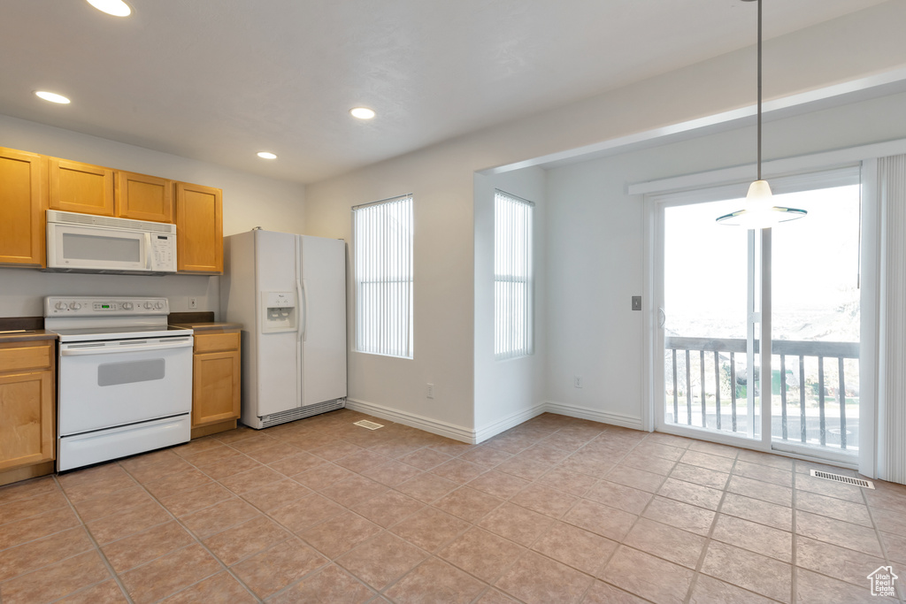 Kitchen with recessed lighting, light tile patterned floors, hanging light fixtures, and white appliances