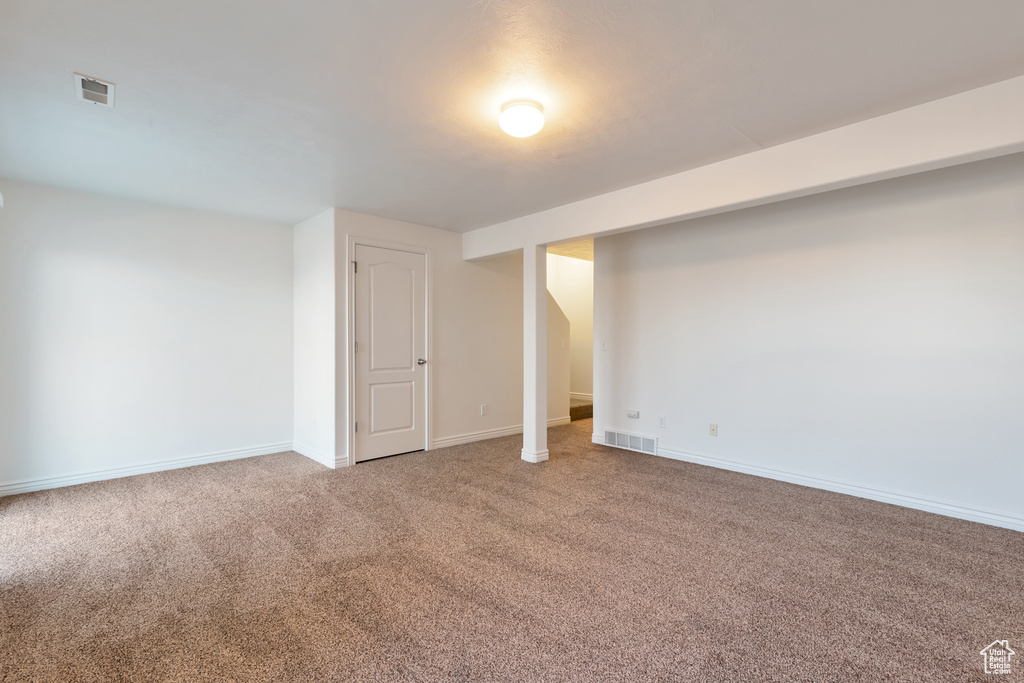Finished below grade area featuring visible vents, baseboards, and carpet floors