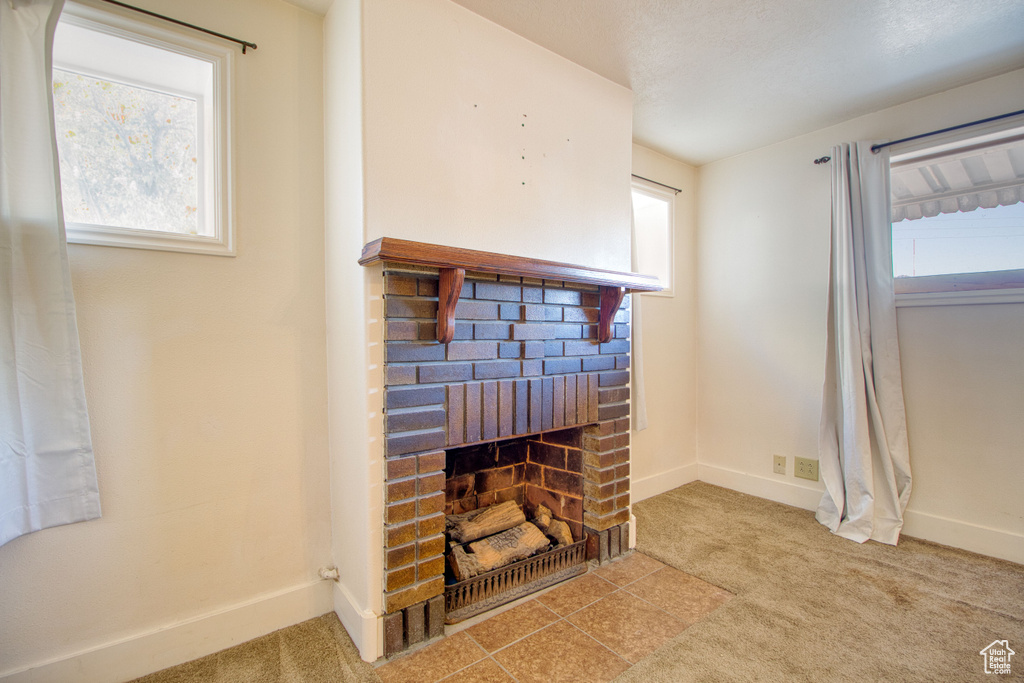 Room details with baseboards, carpet, and a brick fireplace