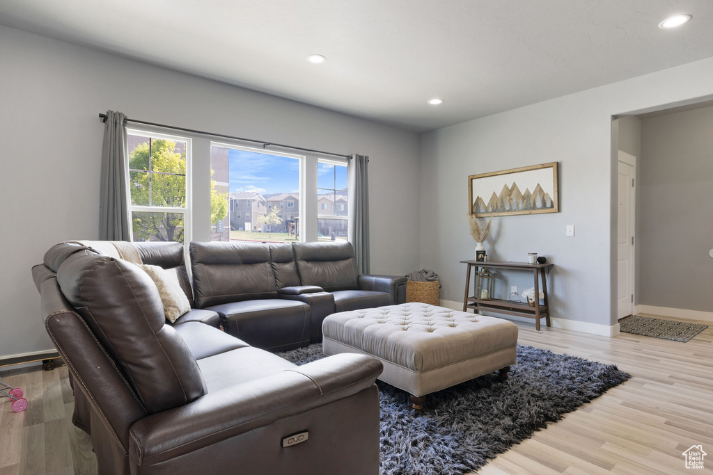 Living area featuring baseboards, recessed lighting, and light wood-style flooring