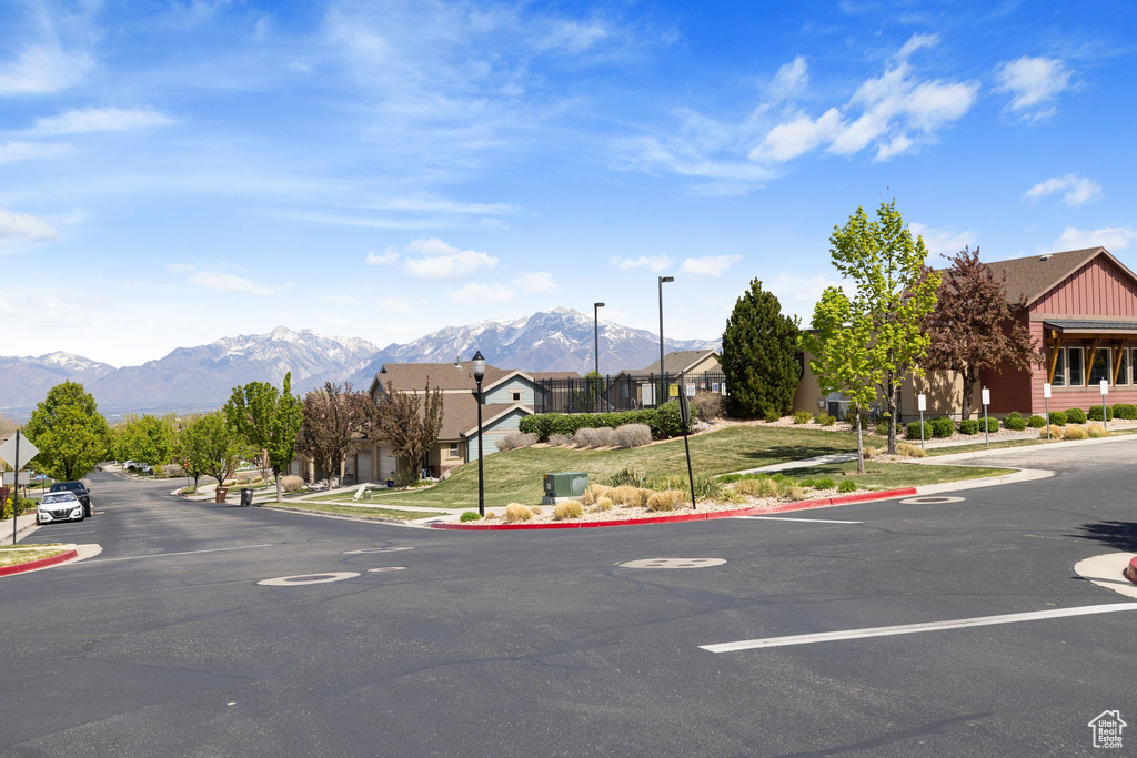 View of street featuring curbs, a residential view, a mountain view, street lights, and traffic signs