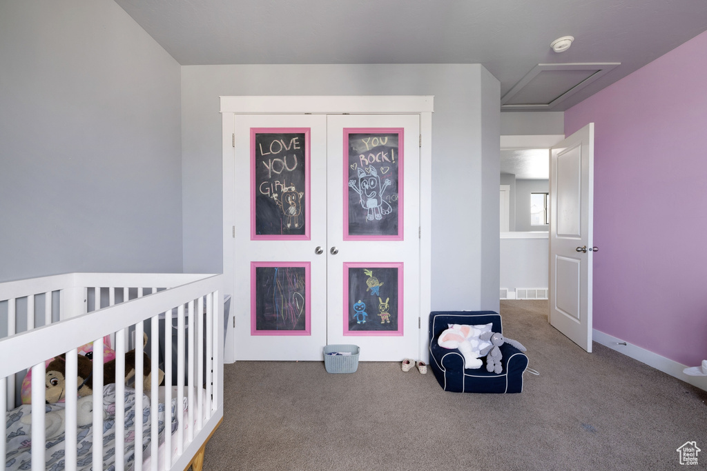 Bedroom featuring carpet floors, visible vents, a closet, and a crib
