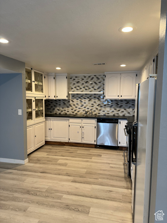 Kitchen featuring stainless steel appliances, light wood-type flooring, and white cabinetry