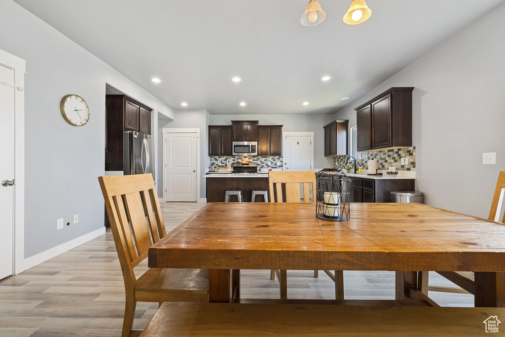 Dining area featuring recessed lighting, baseboards, and light wood-type flooring