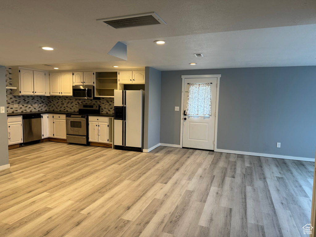 Kitchen featuring visible vents, dark countertops, appliances with stainless steel finishes, open shelves, and baseboards