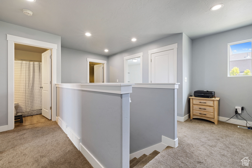 Hall with visible vents, baseboards, an upstairs landing, carpet flooring, and recessed lighting